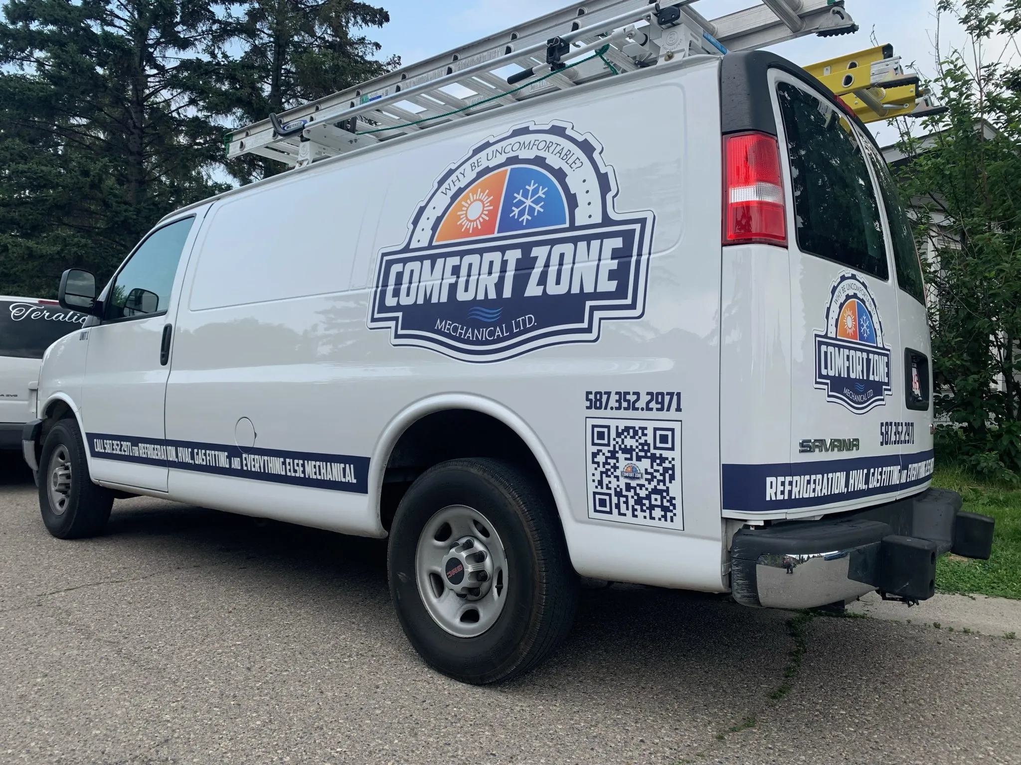 A white van displays branding for a heating and cooling company, parked in a green area
